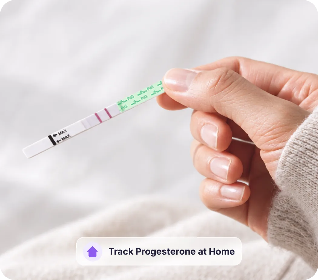 Hand holding a PdG test strip after ovulation