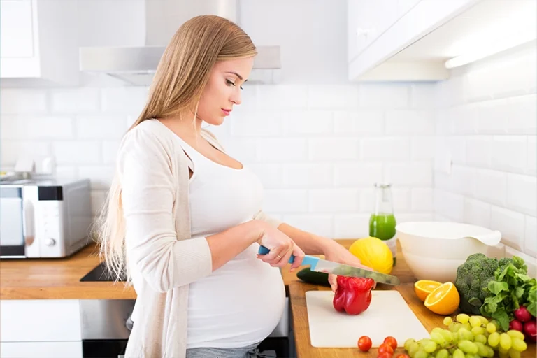 pregnant women chopping food while deciding healthy ideas of what to eat