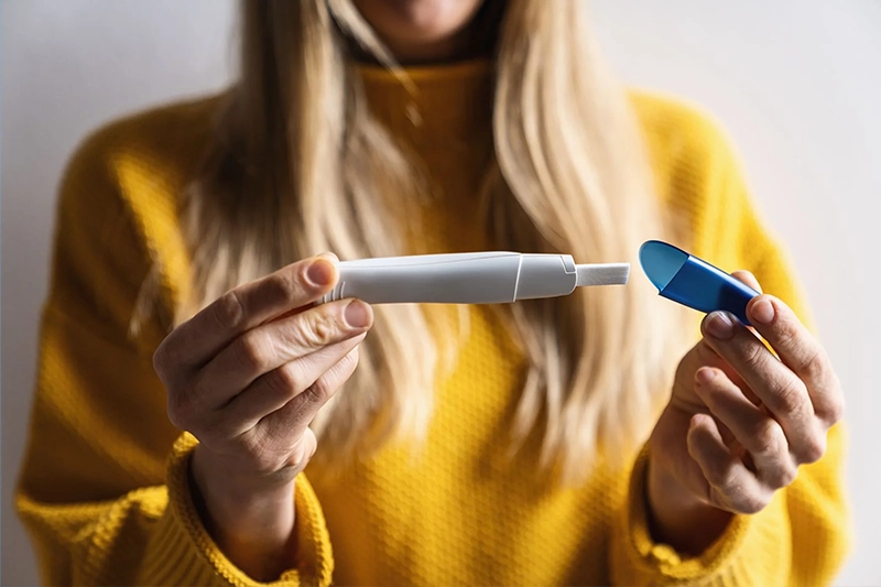 woman holding a pregnancy test and checking the results